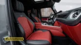 2026 Mercedes-Benz G-Class MBS Edition front-passenger interior side profile view highlighting the red and black quilted leather bucket seat and door panel