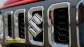 2026 Suzuki Jimny GLX AT chrome front grille closeup highlighting the Suzuki emblem and vertical slats
