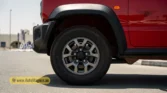 2026 Suzuki Jimny GLX AT front alloy wheel and rugged black wheel arch trim detail closeup