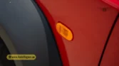 2026 Suzuki Jimny GLX AT side amber turn signal indicator light and red body panel detail closeup