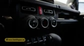 2026 Suzuki Jimny GLX AT center console climate control knobs, hazard warning button, and power window switches closeup