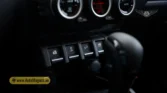 2026 Suzuki Jimny GLX AT center stack toggle switches, power window buttons, and gear selector lever detail closeup